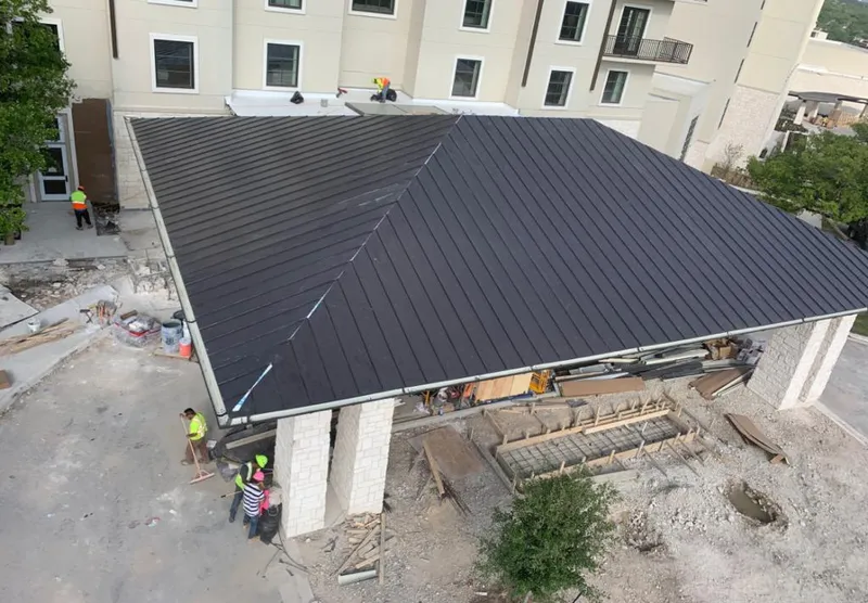 Metal roofing installation team working on a commercial building in Roosevelt
